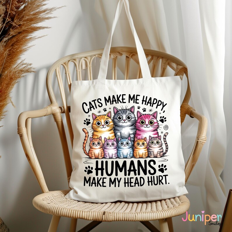 Puede incluir: Bolso tote blanco con una ilustraci&oacute;n colorida de seis gatos de dibujos animados y el texto "CATS MAKE ME HAPPY, HUMANS MAKE MY HEAD HURT." Los gatos son de varios colores, incluyendo naranja, gris, rosa y azul. El bolso tiene dos asas blancas.