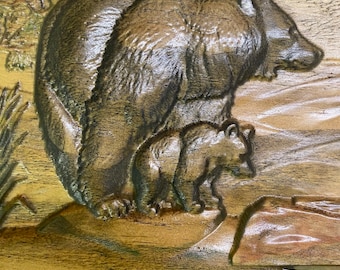 May include: A carved wooden wall art piece depicting a brown bear and a cub. The bear is standing on a rock with its cub standing in front of it. The background is a light brown wood with a green tree in the corner.