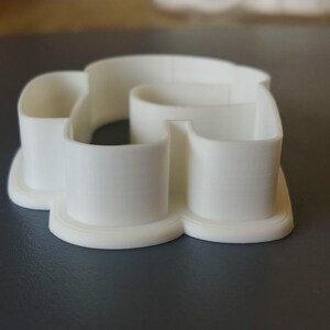 May include: White plastic cookie cutter shaped like a heart with a smaller heart cut out in the center.