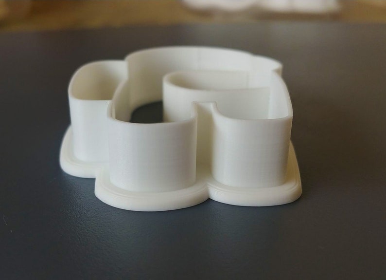 May include: White plastic cookie cutter shaped like a heart with a smaller heart cut out in the center.