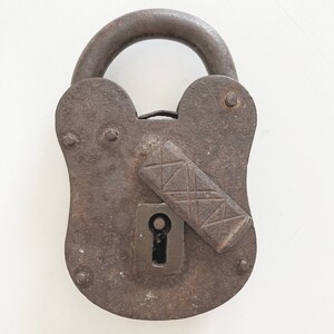 May include: A rusty metal padlock with a keyhole and a decorative latch. The padlock is heart-shaped.