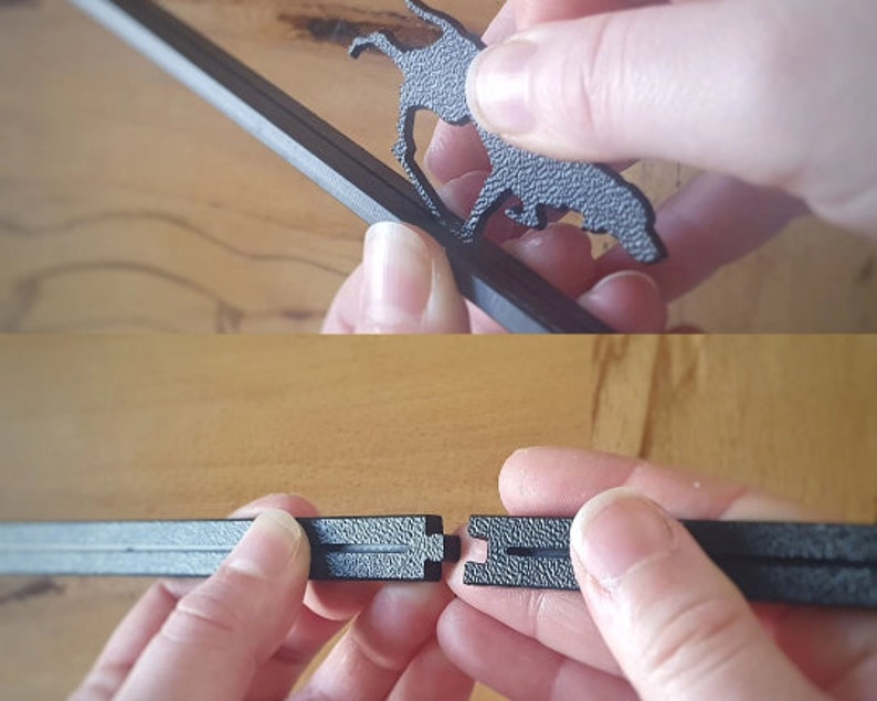 May include: Close-up of a black metal frame with a decorative cutout of a dog. The frame is being assembled by two hands.