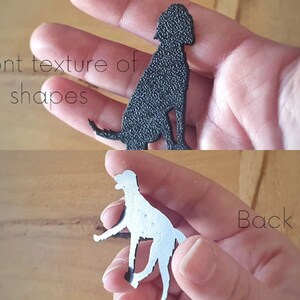 May include: A black dog silhouette cutout with a textured front and a smooth back.