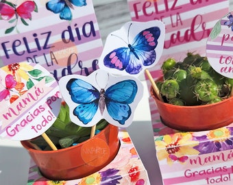 May include: A set of three colorful gift boxes with a floral design and butterflies. The boxes have the text "Feliz dia de la Madre" and "Mamá Gracias por todo!" printed on them.