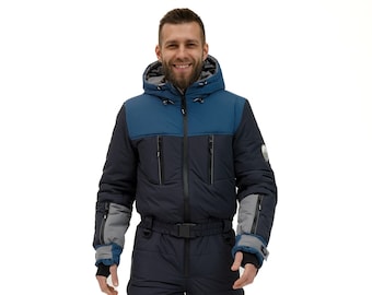 May include: A blue and black winter jumpsuit with a hood and a zipper closure. The jumpsuit has a belt and pockets. The person is wearing black shoes.