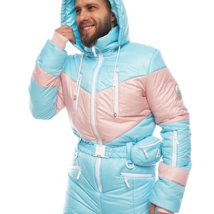 Op de afbeelding: Een lichtblauw skipak met roze en witte accenten. Het pak heeft een capuchon en een ritssluiting. Het pak heeft een riem en zakken.