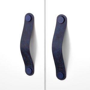 May include: Two dark blue leather cabinet pulls with blue metal screw caps.