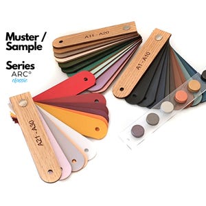 May include: A collection of color sample fans labeled Muster / Sample Series ARC classic, featuring wooden handles and various colored swatches. The sets are marked A1-A10, A11-A20, and A21-A30, accompanied by a clear acrylic strip with circular color buttons.