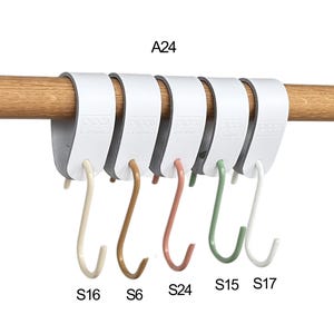 May include: A white, multi-hook organizer with five S-shaped hooks in various colors: beige, brown, coral, green, and white. The organizer is attached to a wooden rod. Text on the organizer reads "A24", and the hooks are labeled "S16", "S6", "S24", "S15", and "S17".