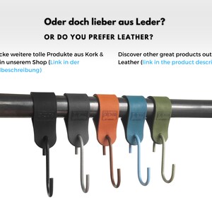 Pu&ograve; includere: Cinque ganci in pelle di diversi colori appesi a una barra di metallo. I ganci sono in pelle e hanno un gancio di metallo nella parte inferiore. I colori dei ganci sono nero, grigio, arancione, blu e verde.