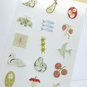 Peut inclure: Une planche d'autocollants avec diverses illustrations. Comprend un oiseau, une poire, un papillon de nuit, des poissons, des fraises, un cygne, un coquillage, un trognon de pomme et d'autres images botaniques. Le texte "sticker sheet" est imprim&eacute; en haut.