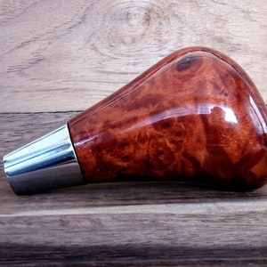 May include: A brown wood and chrome gear shift knob with a burl wood pattern.