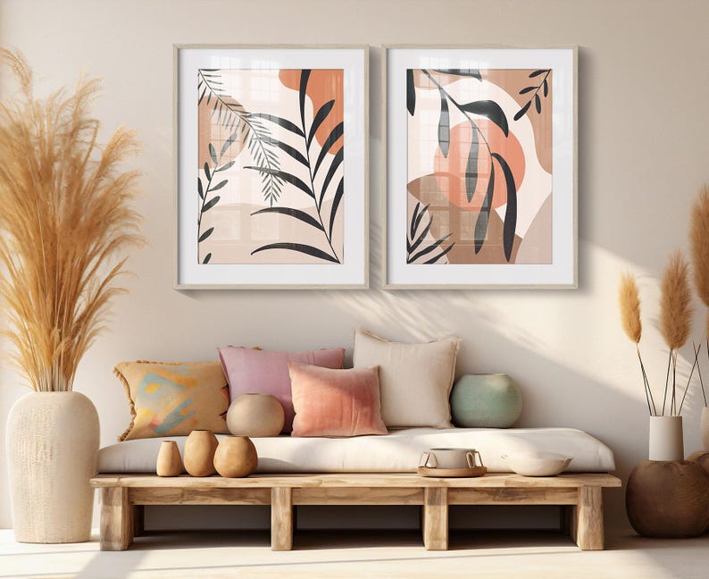 May include: Two framed abstract art prints with a neutral color palette of beige, brown, and peach. The prints feature stylized leaves and organic shapes.