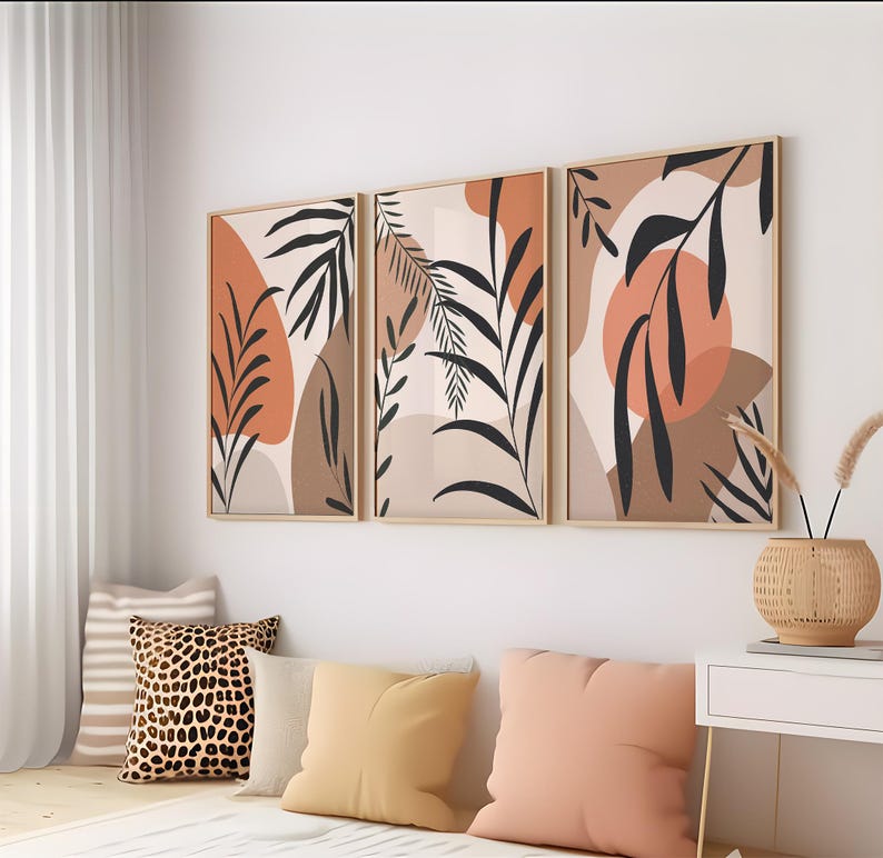 May include: Three abstract art prints with a minimalist design featuring brown, beige, and orange colors. The prints depict stylized leaves and organic shapes.