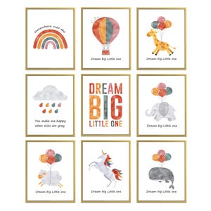 Op de afbeelding: Set van negen aquarelprints met verschillende dieren, een luchtballon, een regenboog en een wolk met regendruppels. Elke print heeft de tekst "Dream big Little one" onderaan.