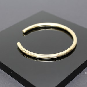 Peut inclure: Un bracelet jonc en or simple. Le bracelet est lisse et a une forme arrondie.