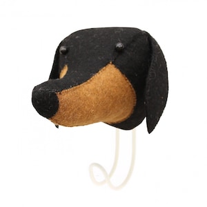 May include: A black and brown felt dachshund dog head wall hanging with black button eyes. The dog head is attached to a white metal hook.