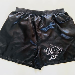 Pode incluir: Shorts de cetim preto com um gr&aacute;fico branco que diz "Estou louco por voc&ecirc;" com um cora&ccedil;&atilde;o e uma flecha.