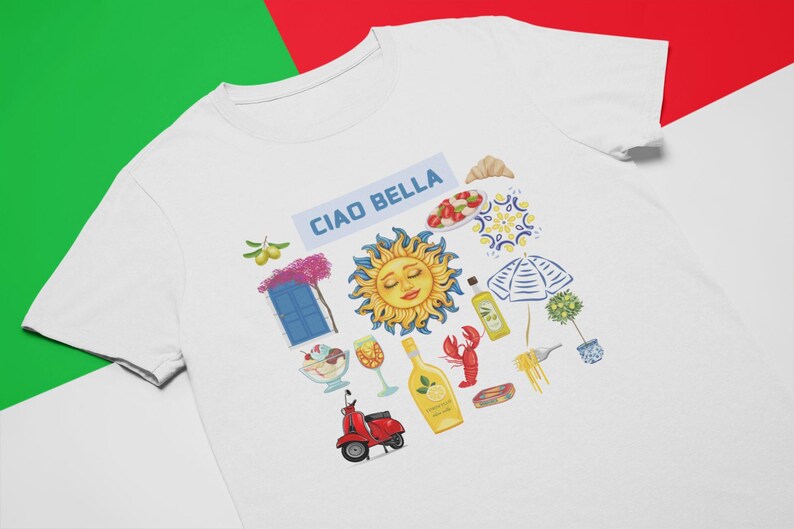 May include: White t-shirt with a colorful graphic design featuring the text "Ciao Bella" and various Italian-themed illustrations, including a sun, a scooter, a bottle of limoncello, and a lemon.