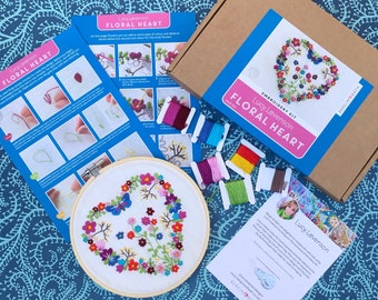 May include: A floral heart embroidery kit with a wooden hoop, colourful embroidery floss, and instructions. The kit includes a pre-printed fabric with a heart-shaped design and a butterfly.