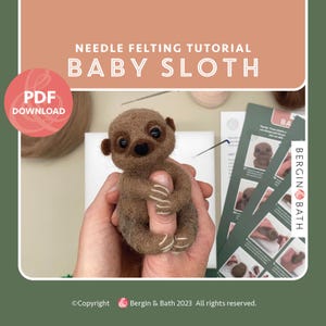 May include: A needle felting tutorial for making a baby sloth. The tutorial includes a PDF download and step-by-step instructions. The image shows a brown and white baby sloth being held in a person's hands. The sloth is made of wool and has a cute, cuddly appearance. The tutorial is by Bergin & Bath.