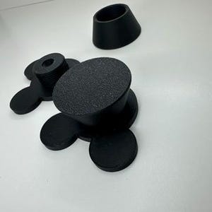 以下が含まれることがあります： 黒いゴム製の家具用脚で、表面はざらざらしており、ベースは丸いです。これらの脚は、家具の脚の底に取り付けるように設計されています。画像には、ねじ付きのポストが付いたものなど、いくつかの脚が写っています。