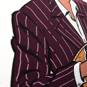 May include: A close-up of a pinstripe suit jacket with a burgundy base and thin white stripes. The jacket is partially unbuttoned, revealing a white collared shirt underneath.