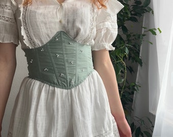 Corset in hellem grün mit aufgestickten Perlen