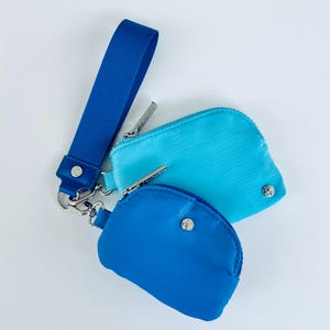Puede incluir: Dos peque&ntilde;as bolsas con cremallera con una correa de mu&ntilde;eca. La bolsa de arriba es azul claro y la bolsa de abajo es azul oscuro.