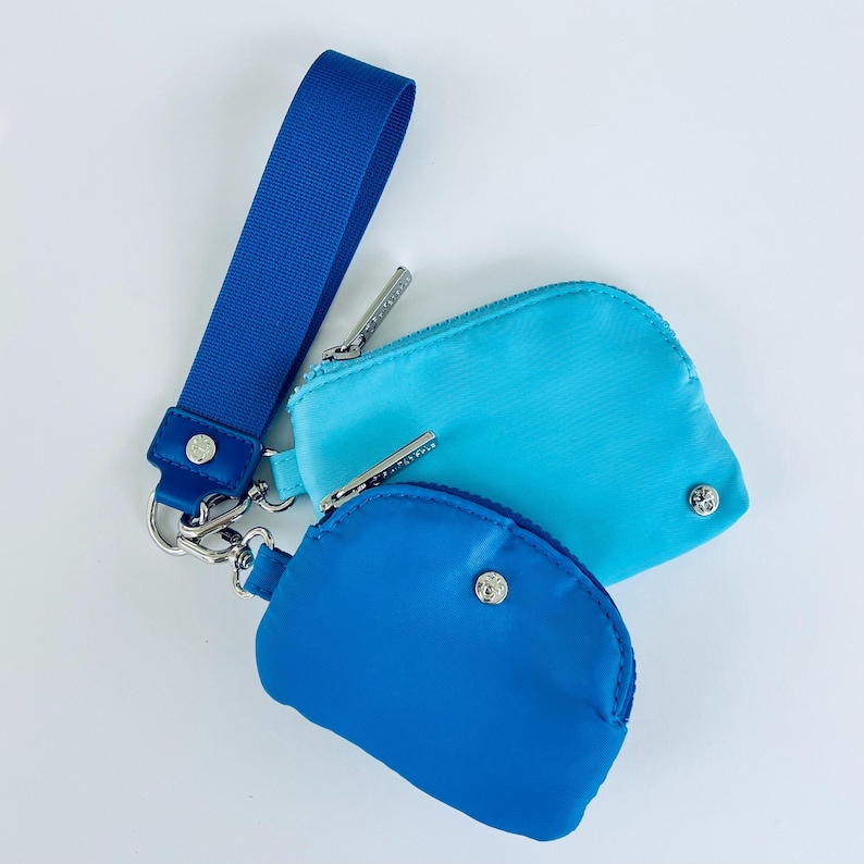 Puede incluir: Dos peque&ntilde;as bolsas con cremallera con una correa de mu&ntilde;eca. La bolsa de arriba es azul claro y la bolsa de abajo es azul oscuro.