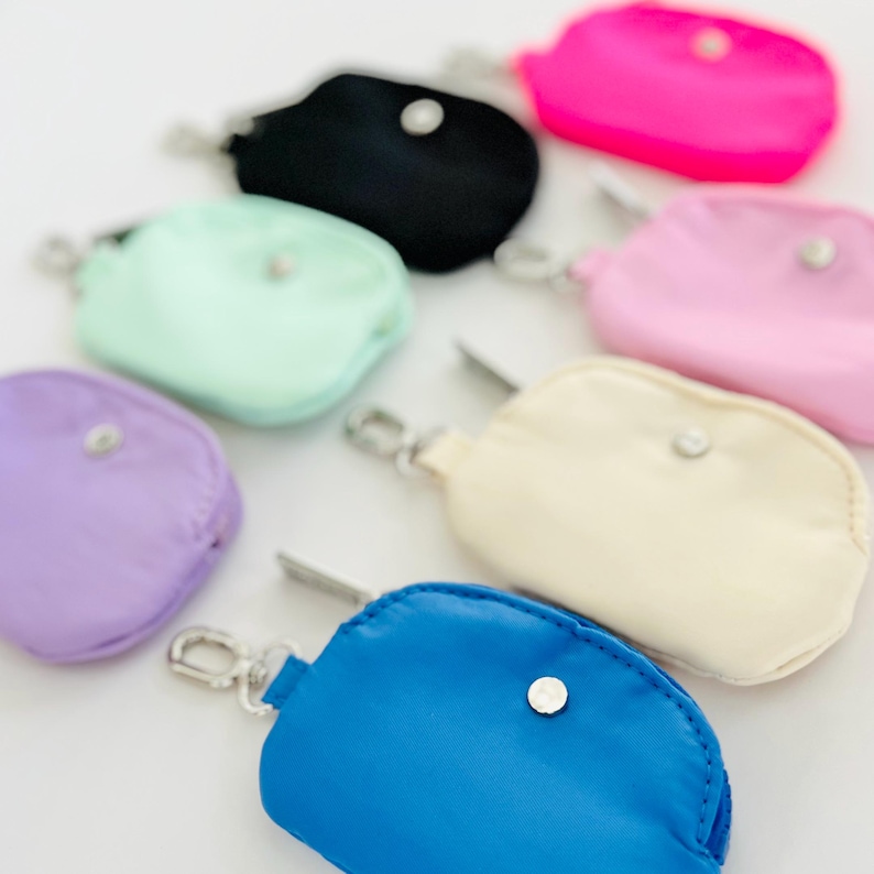 Puede incluir: Un conjunto de ocho peque&ntilde;as bolsas con cremallera de colores con un clip plateado. Las bolsas est&aacute;n hechas de un material suave, similar al nailon, y est&aacute;n disponibles en una variedad de colores, incluyendo rosa, azul, verde, morado y crema.