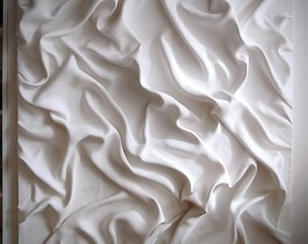 May include: White, three-dimensional wall sculpture resembling a piece of fabric with folds and wrinkles. The sculpture is made of a smooth, white material and has a textured surface.