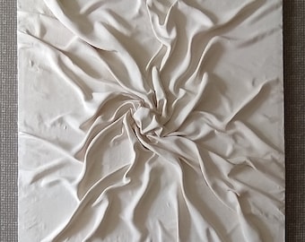 May include: A white fabric sculpture with a swirling, textured design. The fabric is draped and folded to create a three-dimensional effect.