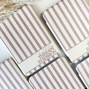 May include: Multiple phone cases featuring a vertical striped design in white and mauve. Each case displays the text "do not disturb THERAPY IN SESSION" in mauve. The cases are arranged on a white surface.