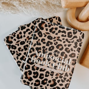 May include: Two leopard print book covers with the text "Antisocial Book Club: Too Booked To Be Bothered". The covers are tan with black and brown spots.