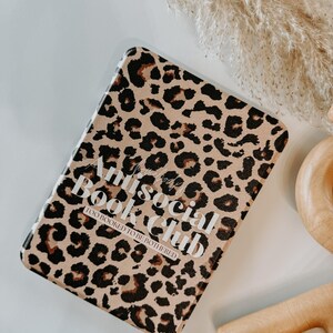 May include: A rectangular book cover with a leopard print pattern in shades of brown and black. The cover features the text "Antisocial Book Club" in white, with "Too Booked to be Bothered" below. The background is white.