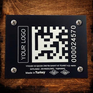 Puede incluir: Letrero rectangular negro con un código QR, el texto "YOUR LOGO" y el número "000024570". El letrero está sujeto con cuatro tornillos y tiene el texto "Made in Turkey".