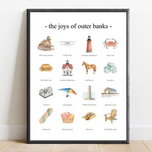 May include: A framed wall art print titled the joys of outer banks featuring a grid of sixteen watercolor illustrations including a lighthouse, crab, wild horse, hang glider, Wright monument, and beach chair with text labels below each icon.