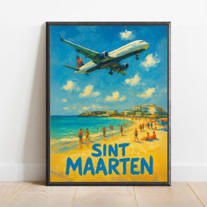 May include: A framed art print of a beach scene with a plane landing. The artwork features a blue sky with clouds, turquoise water, and a sandy beach with people. The text "SINT MAARTEN" is in blue.