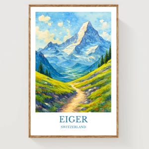Puede incluir: Impresión en acuarela de la montaña Eiger en Suiza. La obra presenta un camino que atraviesa una ladera herbosa verde y amarilla hacia la montaña nevada bajo un cielo azul con nubes. Las palabras "EIGER" y "SUIZA" están impresas en la parte inferior.
