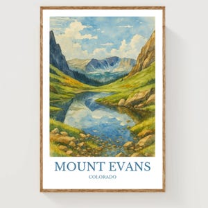 May include: Watercolor print of Mount Evans in Colorado. The artwork depicts a serene mountain lake scene with lush green hills, rocky shores, and a blue sky with fluffy clouds. The text "MOUNT EVANS COLORADO" is printed at the bottom of the image.