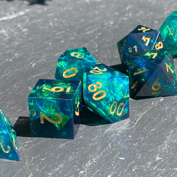 Graviturgy - Captivating Multifaceted Sharp Edge Dice Set- Black Resin with Green Iridescent Foil Inclusions - 7 pc with Gold or Silver Ink