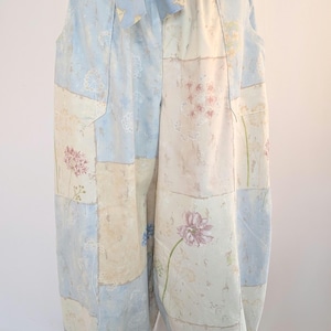 May include: Light blue and cream patchwork pants with floral patterns. The pants have a relaxed fit, pockets, and a matching fabric belt. The fabric is a soft, lightweight material, perfect for casual wear.