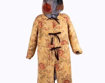 May include: A long, hooded coat with a floral pattern in yellow, red, and green. The coat features dark brown ties and a patterned hood lining. The coat is designed with a relaxed fit and is suitable for various occasions.