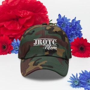May include: A camouflage baseball cap with the text "JROTC Mom" embroidered in white.