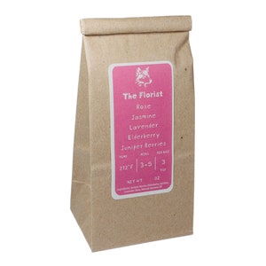 May include: A brown paper bag with a pink label that says "The Florist" and lists the ingredients: Rose, Jasmine, Lavender, Elderberry, Juniper Berries. The label also includes brewing instructions: 212°F, 3-5 min, 3 tsp, and Net Wt 0z.