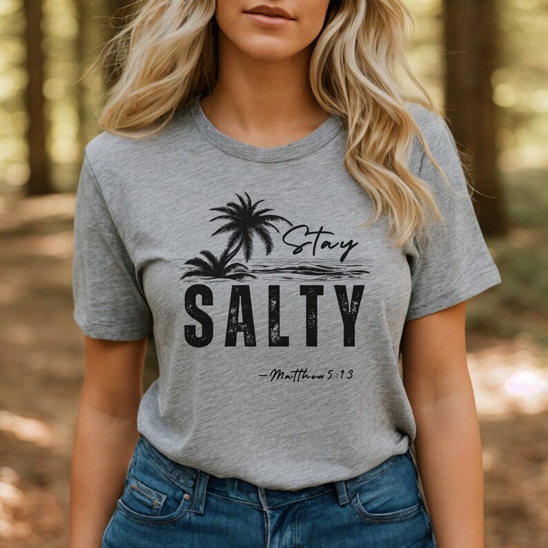 K&ouml;nnte beinhalten: Ein graues T-Shirt mit einer schwarzen Grafik eines Palmenbaums und dem Text "Stay Salty - Matthew 5:13".