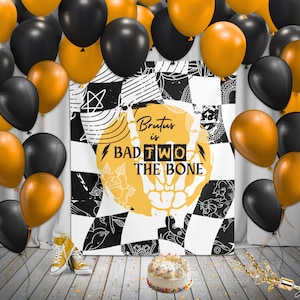 May include: A festive scene with black and gold balloons, a cake, and yellow sneakers. A large sign with the text "Brutus is Bad Two The Bone" is the focal point. The sign has a yellow skull design and a black and white checkered background.