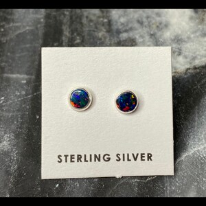 May include: A pair of sterling silver stud earrings with round black opal stones.
