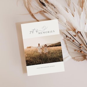 May include: A white card with the text "gift of memories" and a small heart symbol. The card has a photo of a couple and a child walking in a field.